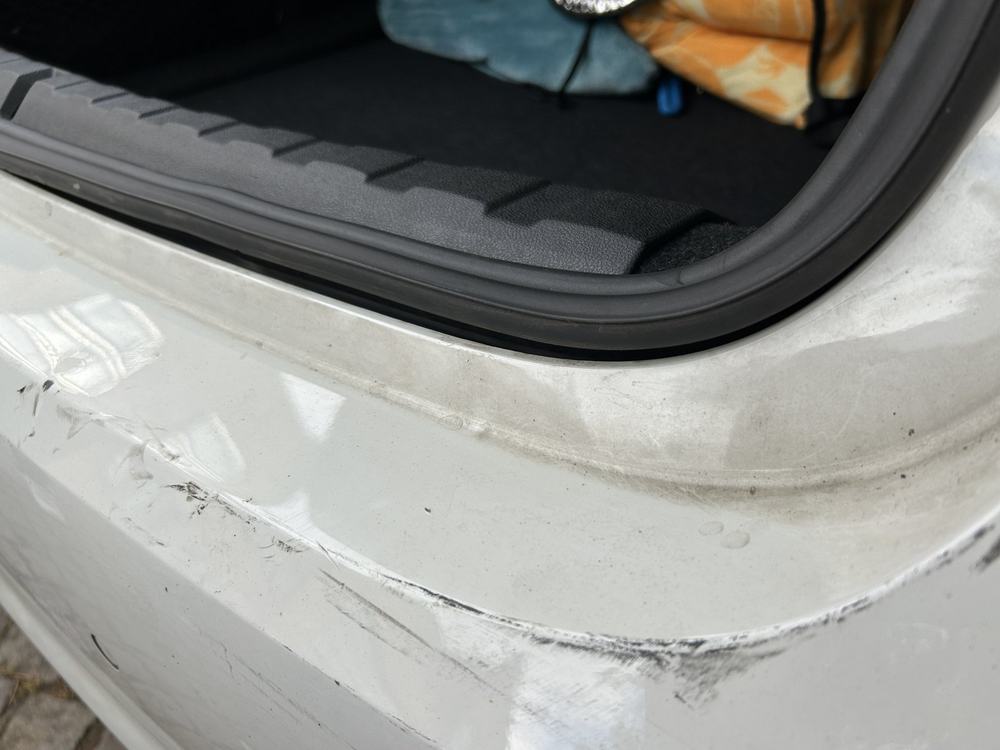 Detailaufnahme Heck: Verformung und Lackabtrag an der Stoßfängerkante, BMW 318d Touring (Wernigerode), Schadenshöhe 8.576,19 € inkl. MwSt.