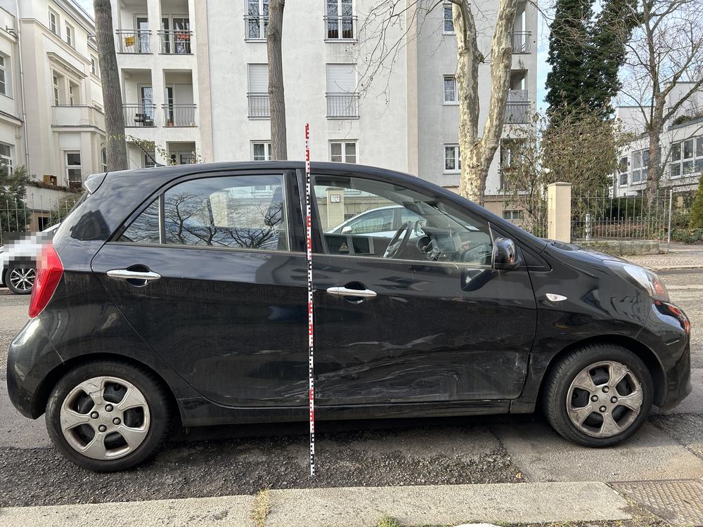 Seitenschaden rechts: Eindrückungen und Schleifspuren über beide Türen, Messlatte angelegt, Kia Picanto IV (Berlin), Schadenshöhe 9.360,23 € inkl. MwSt.