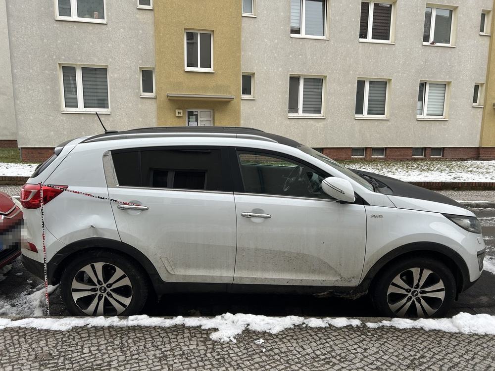 Übersicht rechte Fahrzeugseite mit Messlatte, Schadensschwerpunkt an der hinteren Tür; Kennzeichen im Hintergrund unkenntlich gemacht, Kia Sportage Spirit (Magdeburg), Schadenshöhe 10.952,18 € inkl. MwSt.
