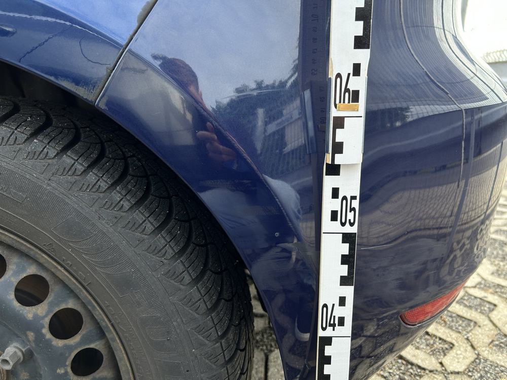 Detailaufnahme hinteres Seitenteil: Eindrückung über dem Radlauf, Messlatte zur Höhenbestimmung angelegt, Volkswagen Golf VI Style (Jena), Schadenshöhe 8.281,21 € inkl. MwSt.